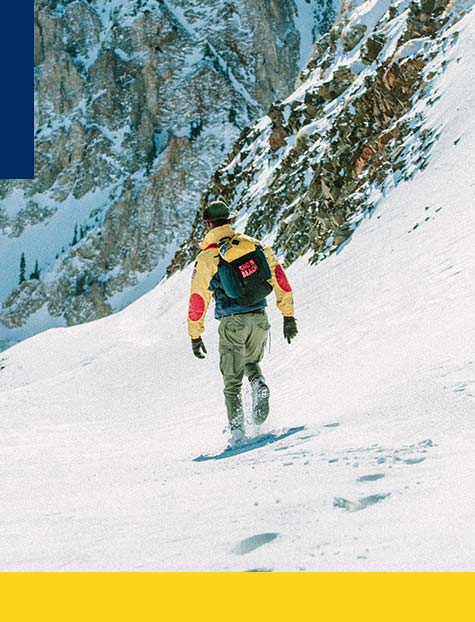 Man in Snow Beach outerwear & backpack on snowy mountain