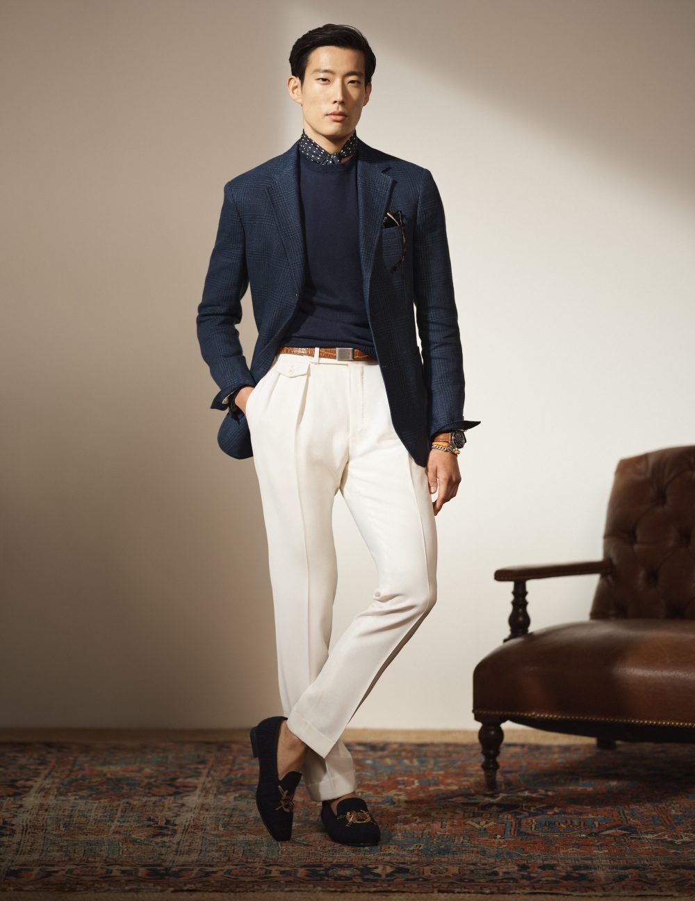 Man wears a navy blue sport coat and white pants.