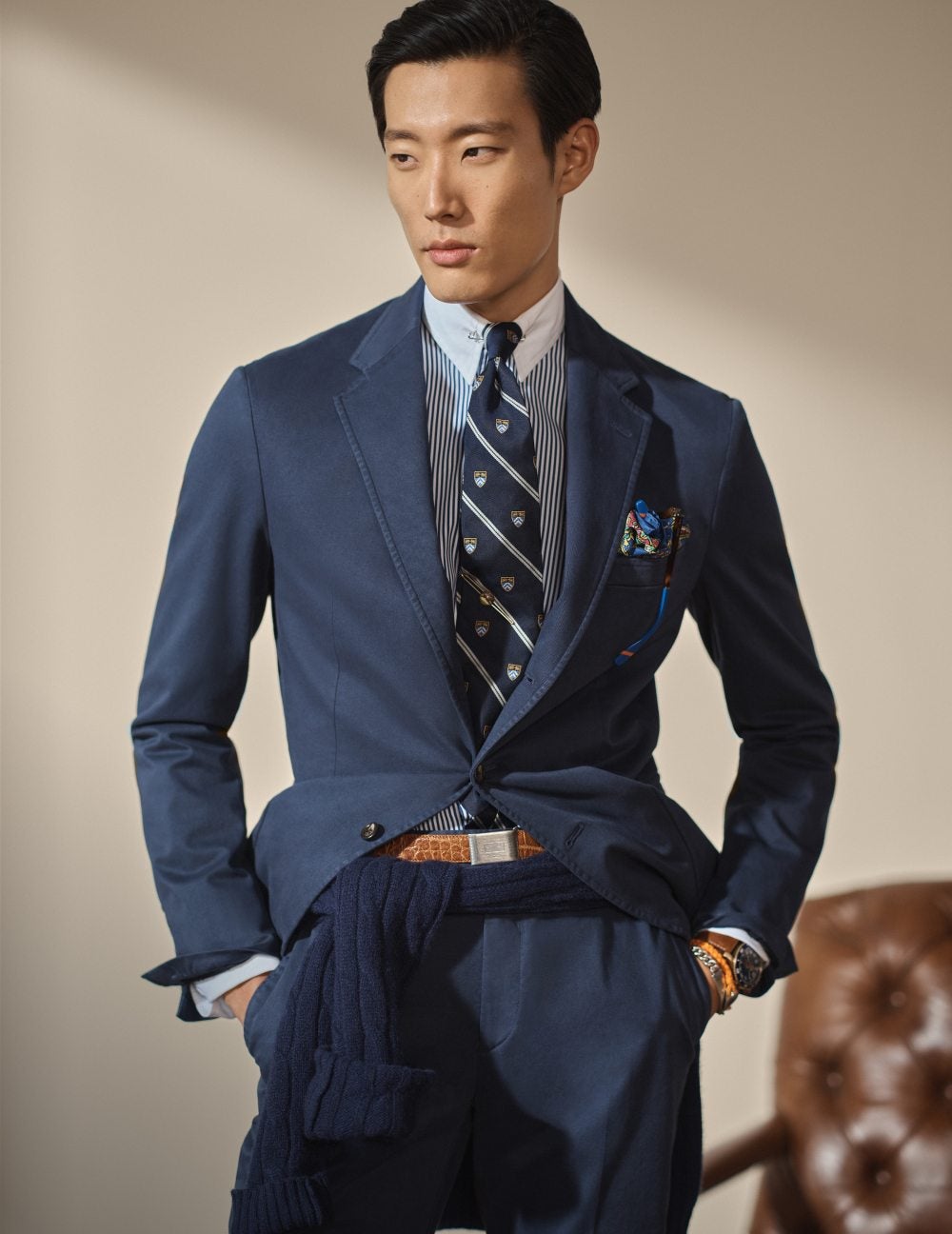 Man wears a navy blue suit and tie.