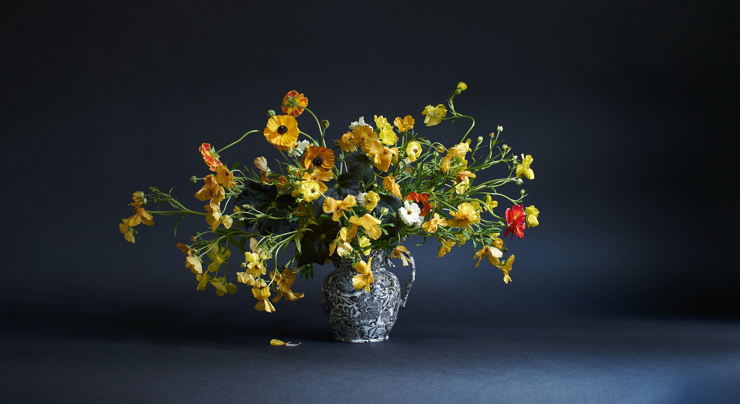 &ldquo;This arrangement uses materials that might feel unusual, but they&rsquo;re actually very accessible. The butterfly ranunculus have tons of great reddish, brown variations. I&rsquo;ve paired them with the dark leaves of a velvety begonia&mdash;a readily available houseplant. The goal here is to use materials that move away from the traditional and commercial. Visually, it&rsquo;s all about an exuberant cloud of movement around the vase.&rdquo; 