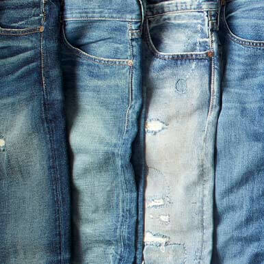 Four pairs of jeans in a row with various washes